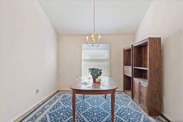 office area featuring an inviting chandelier, baseboards, and vaulted ceiling