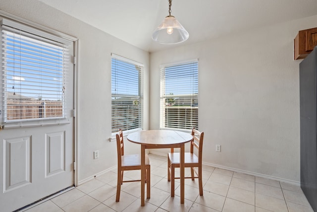 dining area with baseboards and light tile patterned flooring