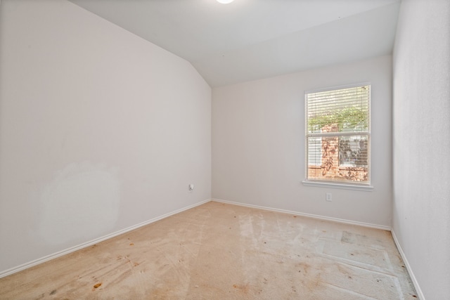 spare room with lofted ceiling, carpet, and baseboards