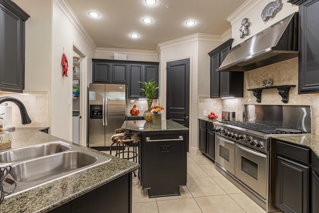 kitchen with a kitchen bar, a kitchen island, stainless steel appliances, wall chimney exhaust hood, and ornamental molding