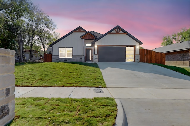 view of front of house featuring a garage and a lawn