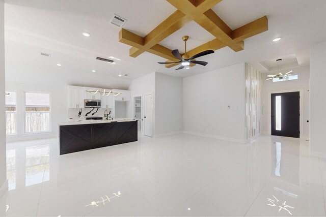 living room featuring coffered ceiling, light tile patterned floors, ceiling fan, and beamed ceiling