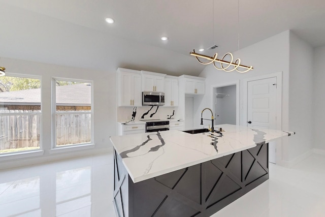 kitchen featuring white cabinets, appliances with stainless steel finishes, and a kitchen island with sink