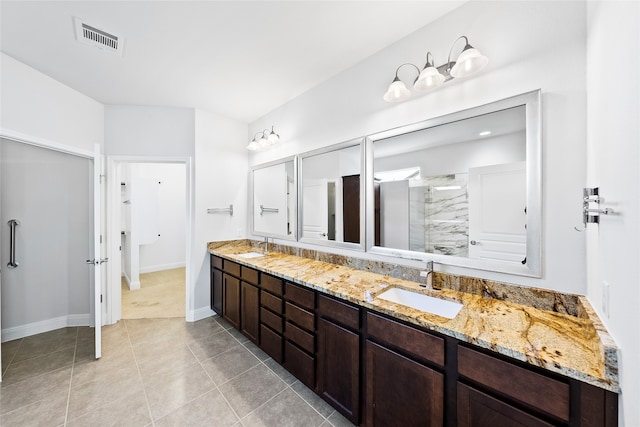 bathroom featuring tile patterned floors, a shower with door, and vanity