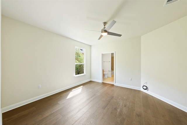 unfurnished bedroom featuring wood-type flooring, ensuite bathroom, and ceiling fan