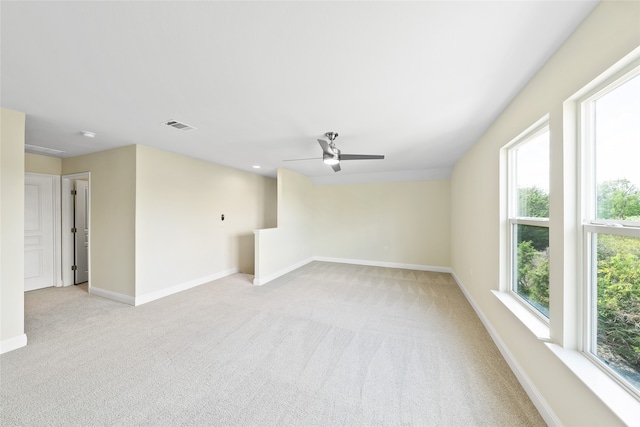 carpeted spare room featuring ceiling fan and a healthy amount of sunlight