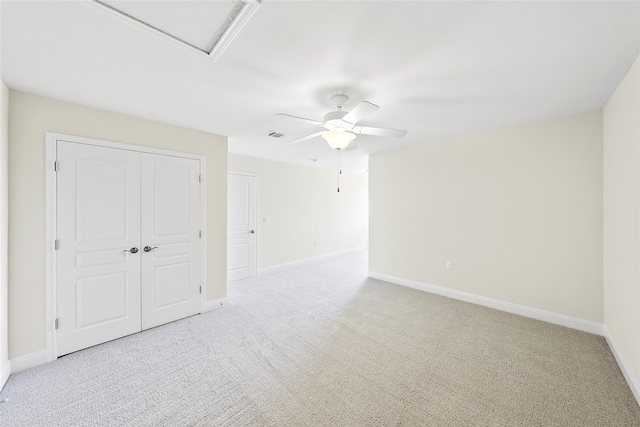 unfurnished bedroom with ceiling fan, light colored carpet, and a closet