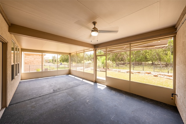 unfurnished sunroom with ceiling fan