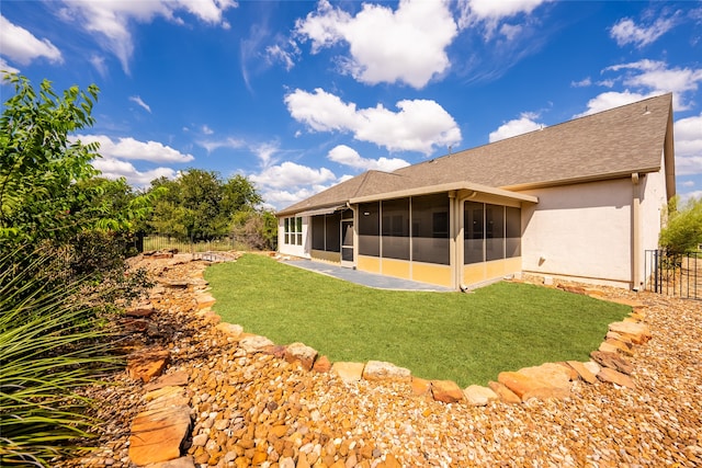 back of house featuring a lawn and a sunroom