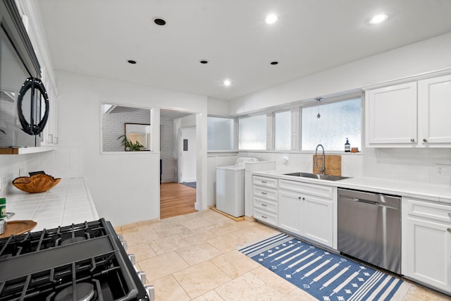 kitchen featuring sink, white cabinetry, dishwasher, and stove