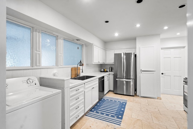 kitchen featuring washer / clothes dryer, stainless steel fridge, white cabinetry, dishwasher, and sink