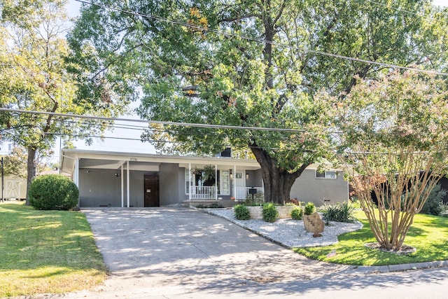 view of front of property featuring covered porch, a front lawn, and a carport