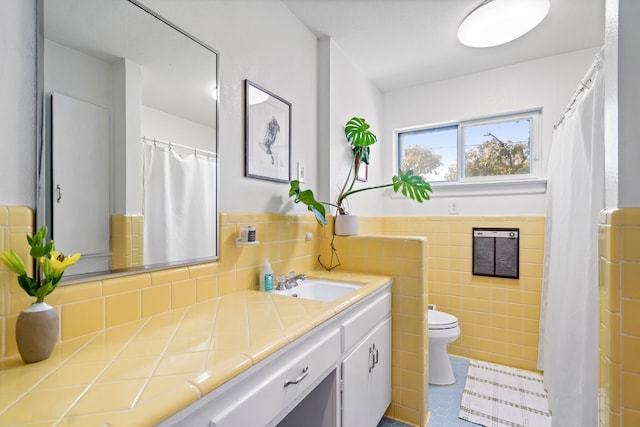 bathroom featuring tile walls, vanity, toilet, and tile patterned flooring