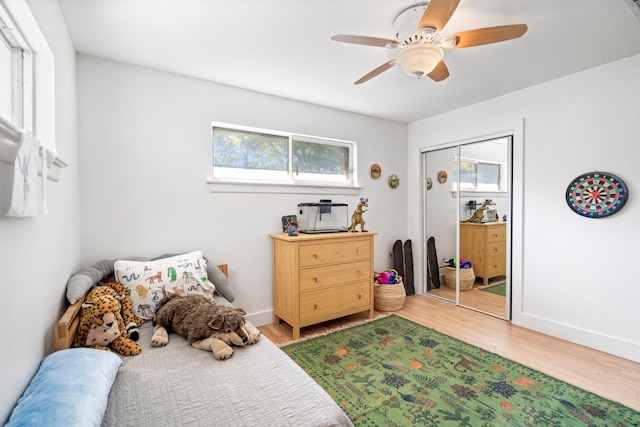 bedroom with wood-type flooring, a closet, and ceiling fan