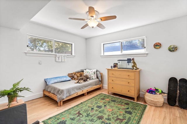 bedroom featuring multiple windows, hardwood / wood-style floors, and ceiling fan