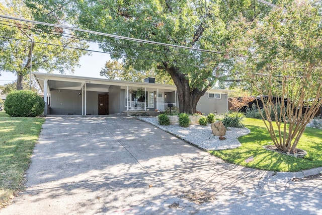 ranch-style house with a front lawn, covered porch, and a carport