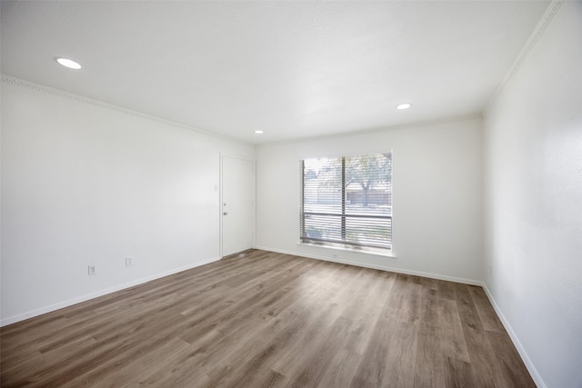 unfurnished room featuring hardwood / wood-style floors and crown molding