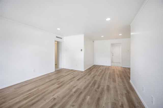 unfurnished room featuring crown molding and light hardwood / wood-style floors