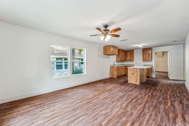 kitchen with a center island, dark wood-type flooring, sink, and ceiling fan