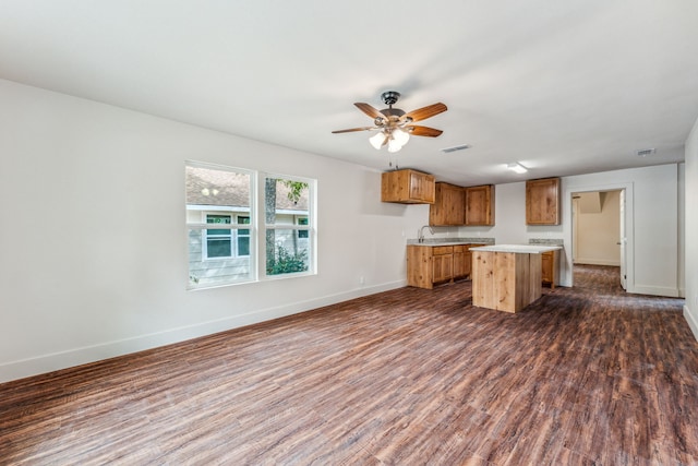 1046 W Green St, Stephenville, TX 76401 - kitchen featuring a center island, light countertops, dark wood-style flooring, and baseboards