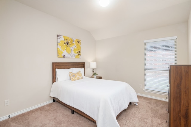 bedroom featuring light carpet and vaulted ceiling