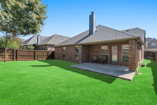 back of house with a patio and a lawn