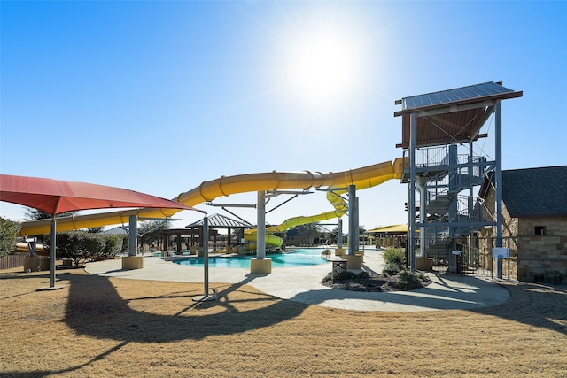 view of playground featuring a gazebo, a community pool, and a patio