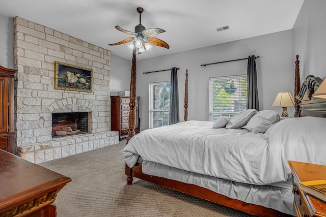 carpeted bedroom with ceiling fan, a fireplace, and access to exterior