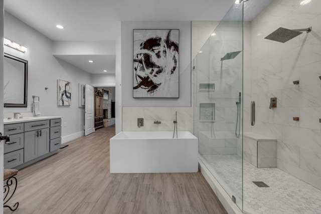 bathroom featuring vanity, shower with separate bathtub, and hardwood / wood-style floors