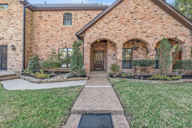 view of exterior entry with a lawn