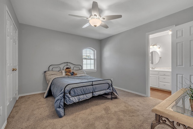 carpeted bedroom with ensuite bath and ceiling fan