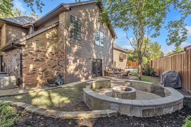 rear view of property with a patio area and an outdoor fire pit