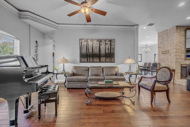 living room featuring hardwood / wood-style floors, crown molding, ceiling fan with notable chandelier, and decorative columns