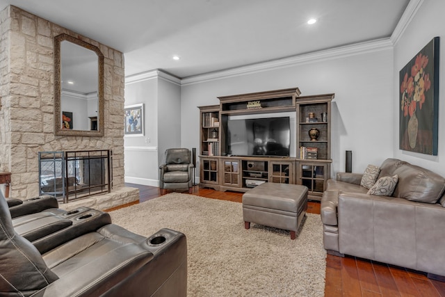 living room with dark wood-type flooring, crown molding, and a fireplace