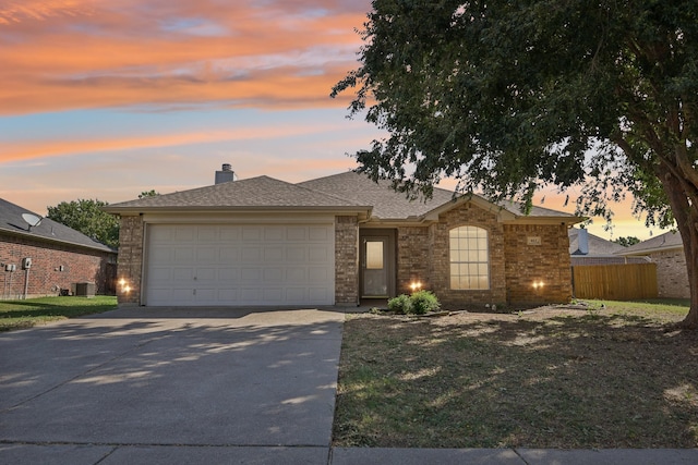 ranch-style home featuring central AC unit and a garage