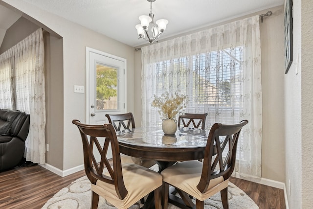 dining area with an inviting chandelier and dark wood-type flooring