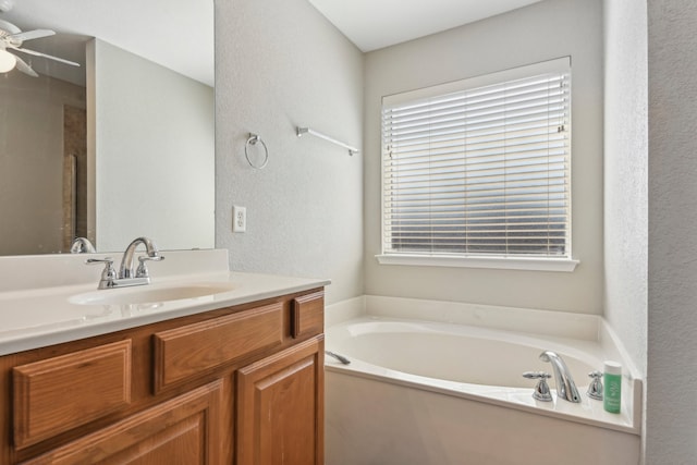 bathroom with vanity, a bathtub, and ceiling fan