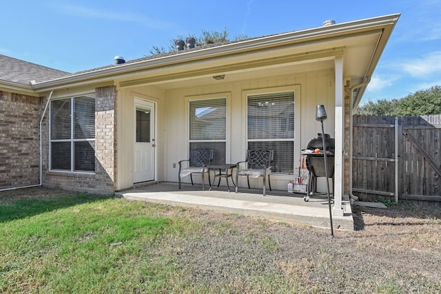 entrance to property featuring a yard and a patio