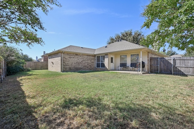 rear view of property featuring a patio area and a lawn