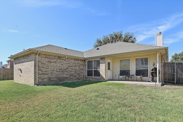 rear view of property featuring a patio and a yard