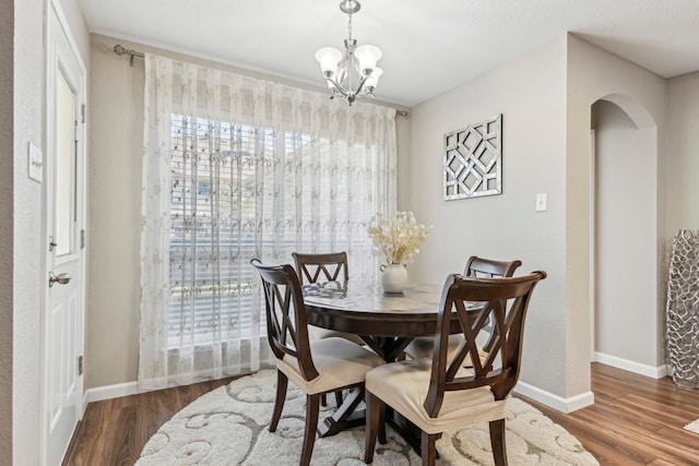 dining space with an inviting chandelier and dark hardwood / wood-style flooring