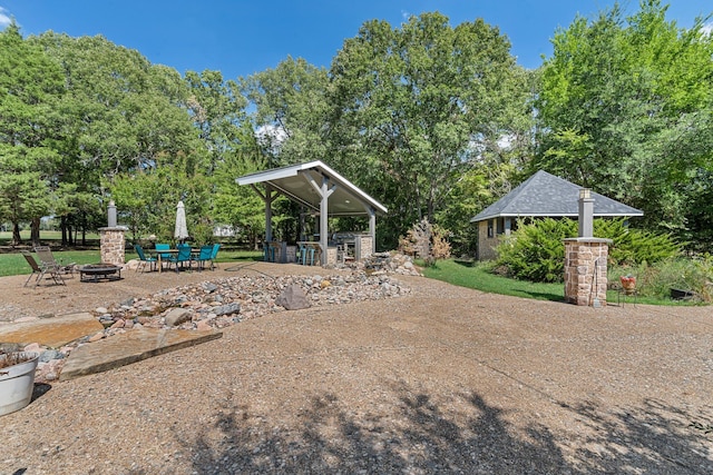 view of yard featuring a gazebo, a patio, and a fire pit