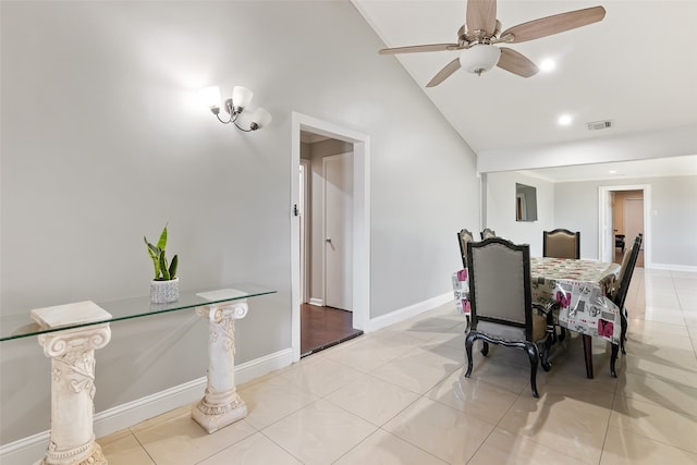 tiled dining area with high vaulted ceiling and ceiling fan