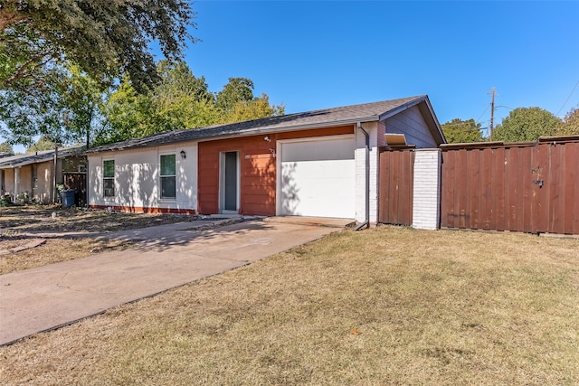 single story home featuring a front lawn and a garage