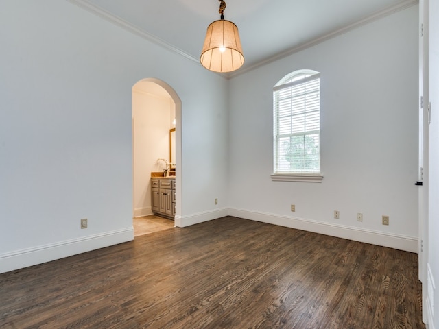 empty room with ornamental molding and dark wood-type flooring