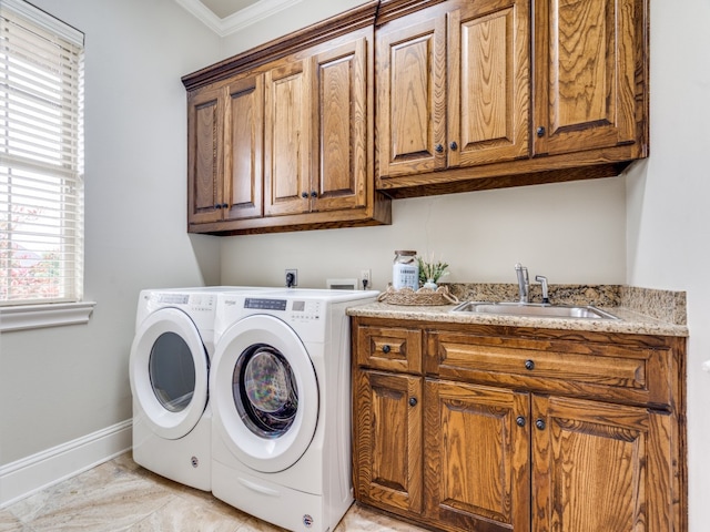 washroom with cabinets, ornamental molding, sink, and washer and dryer