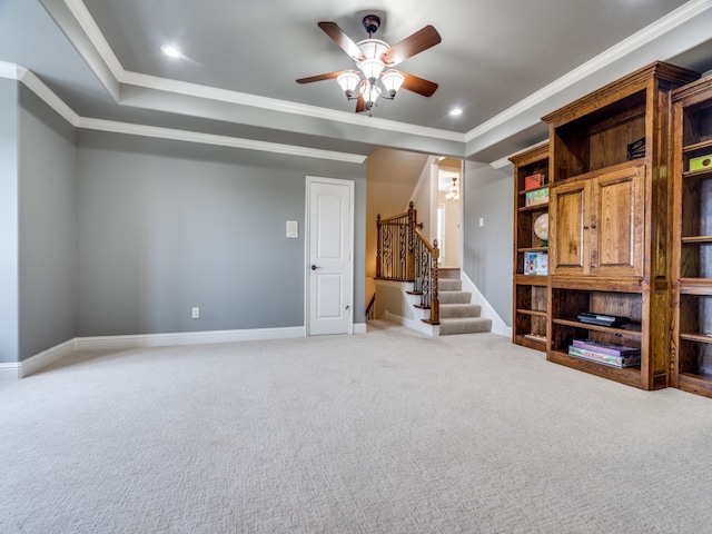 unfurnished living room with ceiling fan, crown molding, carpet, and a tray ceiling