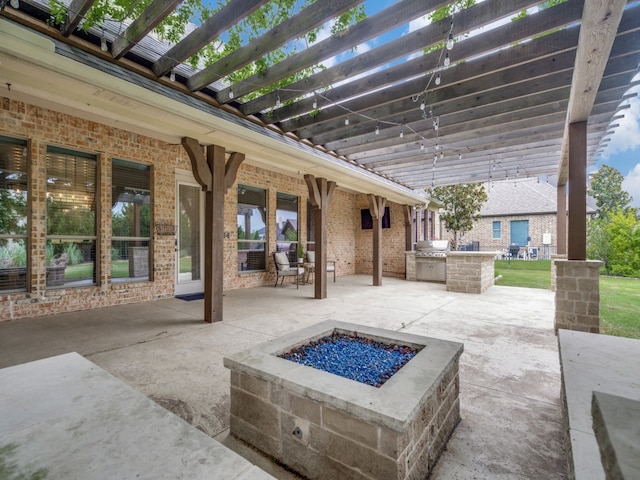 view of patio with an outdoor kitchen, an outdoor fire pit, and a pergola