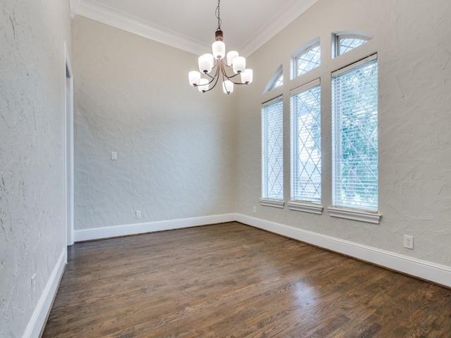 spare room with ornamental molding, a healthy amount of sunlight, a chandelier, and dark wood-type flooring