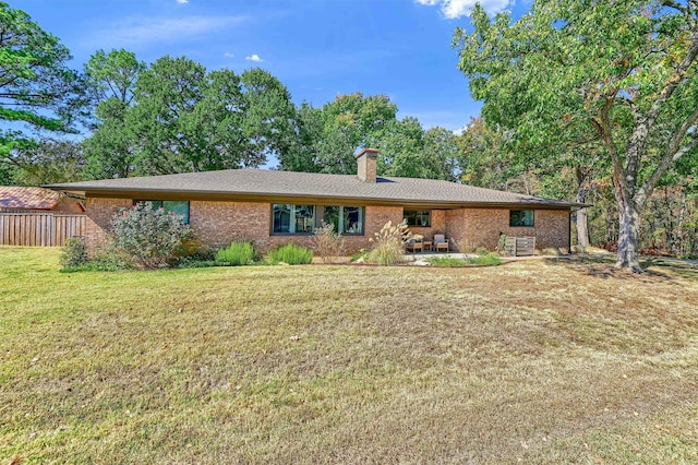 ranch-style home with a front yard and a patio area